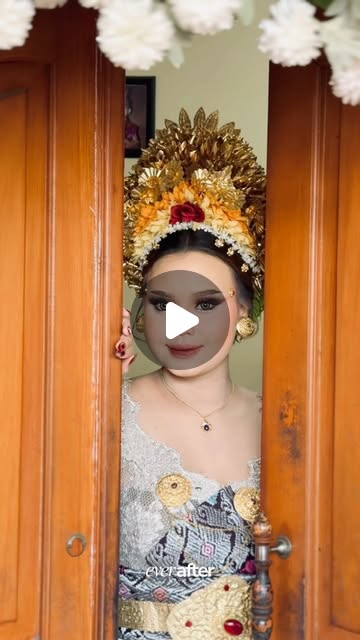 Pebriani framed by wooden doors in traditional Balinese bridal attire